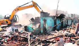 A JCB machine pulls down houses at Colony No. 5 in Sector 51, Chandigarh.