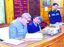 MC president Manmohan Singh Mall reads the proceedings during the Municipal Council meeting in Mussoorie on Saturday.