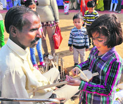 A vendor shows a musical instrument to a child during the Sheetla Saras Fair in Gurgaon on Sunday.