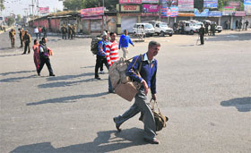 Passengers walk on foot to reach railway station in the absence of public transport on Sunday.