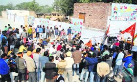 Members of the Bhagwan Valmiki Dhunna Sahib Trust squat in front of the two rooms at Ram Tirath Temple in Amritsar on Monday