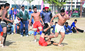 Punjab kabaddi team stopper tries to stall Haryana team raider during the final match; and (below) members of the Haryana kabaddi team show victory signs after winning the match in the 59th National School Games in Bathinda on Monday.
