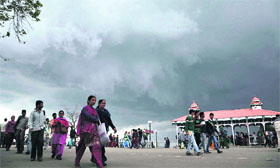 People walk on the Ridge as thick clouds hover over Shimla on Tuesday.