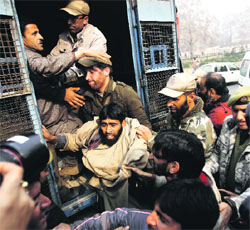 Policemen detain a member of the Jammu and Kashmir Handicapped Association in Srinagar on Tuesday.