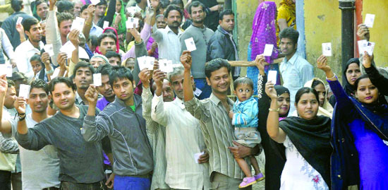 People queue up outside a polling station to cast their votes for the Delhi Assembly elections on Wednesday. 