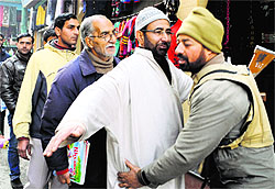 Security personnel frisk people near Lal Chowk in Srinagar on Wednesday