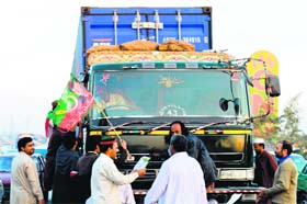 Supporters of Pakistan Tehreek-e-Insaf (PTI) party stop a truck in a bid to block the NATO supply in Peshawar on Wednesday