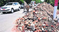 Debris of a building undergoing renovation lies dumped on a road in Gandhi Nagar, Jammu. A Tribune photograph