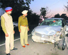 Policemen inspect a car that hit the elderly couple near Rajewal village in Ludhiana. 