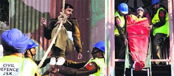 Volunteers of the Home Guard and Civil Defence Organisation conduct a mock rescue operation on its 51st Raising Day in Jammu on Friday.