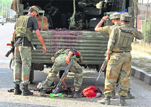 Army jawans collect belongings of slain colleagues after militants attacked a convoy at Hyderpora in Srinagar recently