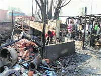 People search for valuables after a fire damaged homes at Lalmati in Guwahtai on Saturday