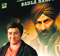 Sunny Deol poses in front of the poster of his latest film 