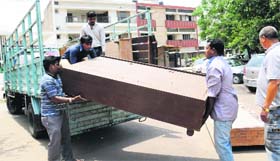 Workers carry furniture from Furniture Market during an anti-encroachment drive in Sector 34, Chandigarh