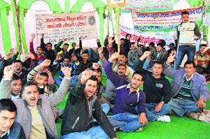 Striking contractual power corporation employees hold a dharna in support of their demands in Dehradun on Sunday.