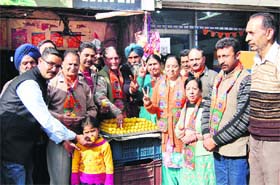 BJP supporters distribute sweets after the party win in state elections on Sunday