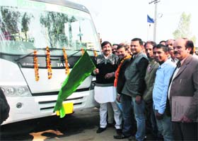 Industry Minister Mukesh Agnihotri flags off a local bus at Dulehar village in Una on Sunday