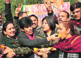 BJP activists celebrate the party's thumping win in the Assembly elections outside the BJP headquarters in Jammu on Sunday