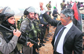 Israeli soldiers look at a man dressed up as late South African leader Nelson Mandela during a protest against the Jewish settlement in the West Bank on Sunday.