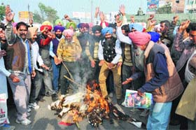 Members of the Water Supply and Sanitation Empolyees Union burn an effigy of the Punjab government in Bathinda on Monday