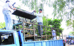 The Municipal Corporation workers carry items confiscated during the anti-encroachment drive at Sector 15 in Chandigarh on Monday. 