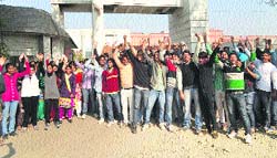 Students of the Global Research Institute of Management and Technology, Nachraun, block a road in Yamunanagar on Monday. A Tribune photograph