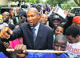 Mandla Mandela marches along with people outside his grandfather Nelson Mandelas home in Johannesburg on Monday.