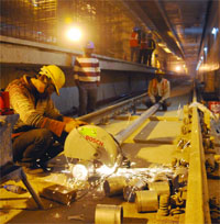 DMRC workers seen at a Metro station under construction in New Delhi on Tuesday
