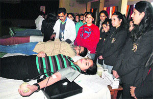 Girls donate blood at a blood donation camp organised at St Bedes College in Shimla on Wednesday.