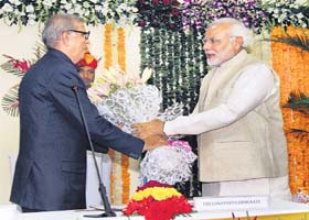 Gujarat Chief Minister Narendra Modi greets Justice DP Buch (retired) after he was sworn-in as the state Lokayukta, in Gandhinagar on Wednesday