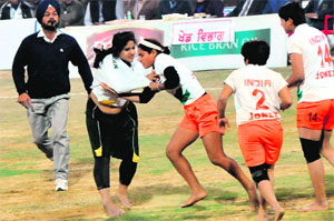 An Indian player wrestles to stop a Pakistan raider during their semifinal in the World Cup Kabaddi on Wednesday.