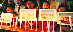 Schoolchildren hold placards and candiles as a tribute to the victims of the 2001 attack on Parliament at a ceremony in Amritsar on Thursday