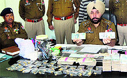 SSP Amritsar (Rural) Gurpreet Singh Gill shows the foreign currency seized from the nabbed criminal in Amritsar on Thursday