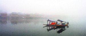 Boatmen row their boats on a cold, foggy day on the Dal Lake in Srinagar on Thursday.