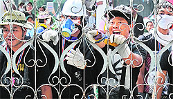 Thai anti-government protesters shout at policemen from outside the besieged Government House compound in Bangkok on Thursday