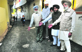 Residents show a newly built damaged road at Butrela village, Sector 41, Chandigarh, on Friday.