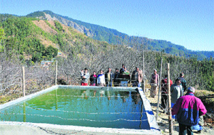 Farmers show a water storage tank constructed through the District Water Development Project at Majhar village.