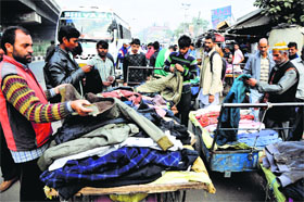 People purchase warm clothes on the BC Road in Jammu on Friday.
