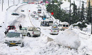 Vehicles stranded in snow at the entrance of Jerusalem following a snowstorm on Friday.