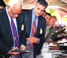 Governor NN Vohra examines a weapon at Red Cross Mela in Gulshan Ground, Jammu, on Saturday. 