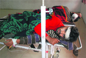 An injured at the General Hospital in Panchkula; and (below) police officials at the site where the accident took place on Sunday.