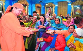 Spiritual guru Pusphnandan Maharaj distributes copies of Bhagwad Gita to devotees on the occasion of Gita Jayanti in Haridwar
