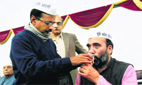 Aam Aadmi Party convenor Arvind Kejriwal offers juice to party leader Gopal Rai to break his fast which he was holding for the Jan Lokpal Bill in New Delhi on Sunday.