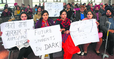 Members of the Indian Medical Association, Jalandhar unit, and paramedical staff hold a protest on the premises of the Punjab Institute of Medical Sciences in Jalandhar on Monday. 