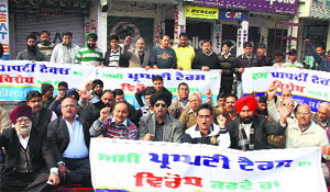 Traders and shopkeepers of Shastri Market protest against the high rates of property tax on commercial buildings, in Jalandhar on Monday.