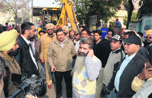Congress MLA Bharat Bhushan Ashu disrupting an MC demolition drive in the Jawahar Nagar Camp on Monday. 