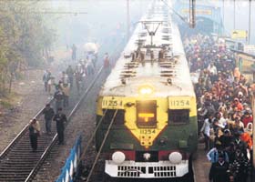 Passengers board a train amid thick fog in Kolkata