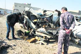 An Iraqi policeman looks at a damaged vehicle on Monday