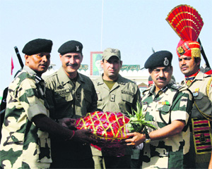 BSF Deputy Inspector General MF Faroqui (2nd from right) gives a gift to Pakistani Ranger Wing Commander Asher Khan (2nd from left) during Eid-al-Adha festival at the Attari-Wagah Joint Check post. 