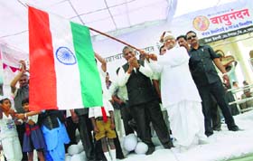 Social activist Anna Hazare waves the Tricolour after Lok Sabha passed the Lokpal Bill, at Ralegan Siddhi in Maharashtra on Wednesday